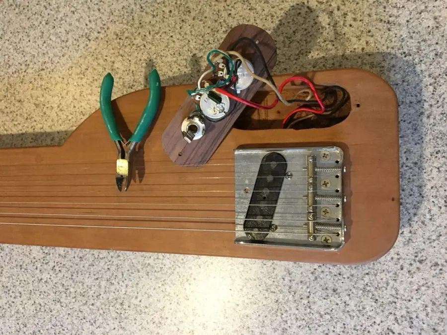 Wiring a control plate with pliers on a custom lap steel build