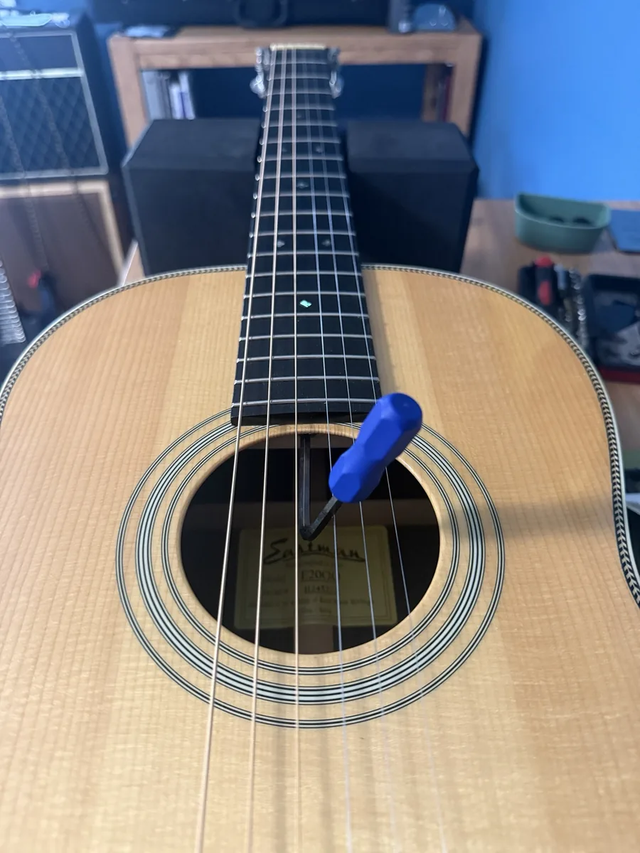 Truss rod adjustment being made through the soundhole of an Eastman acoustic guitar
