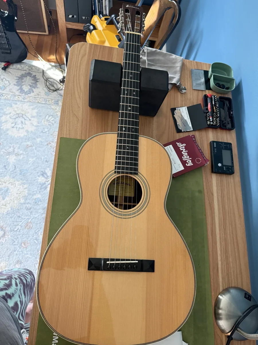 Eastman E20 OO acoustic guitar during setup with Stringjoy strings on the workbench