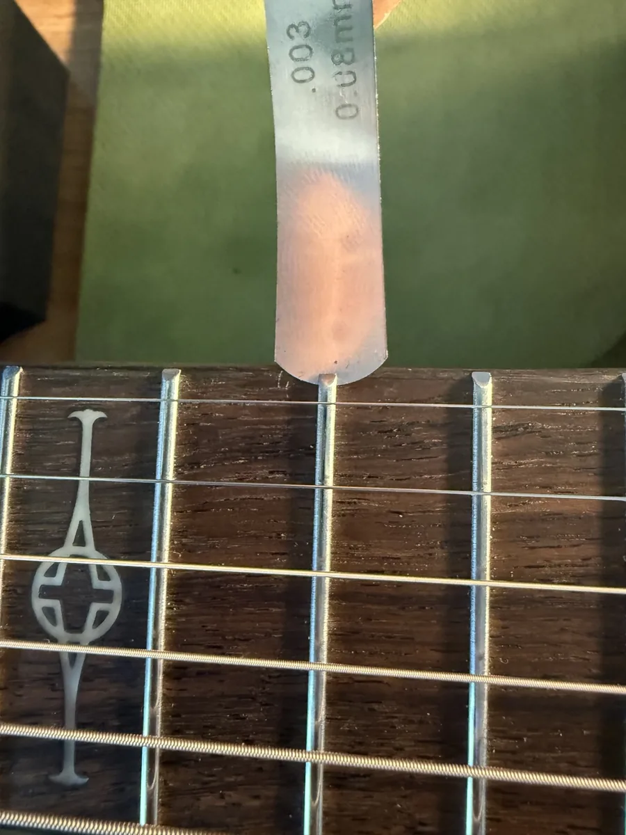 Close-up inspection of the loose 13th fret on an Alvarez acoustic guitar