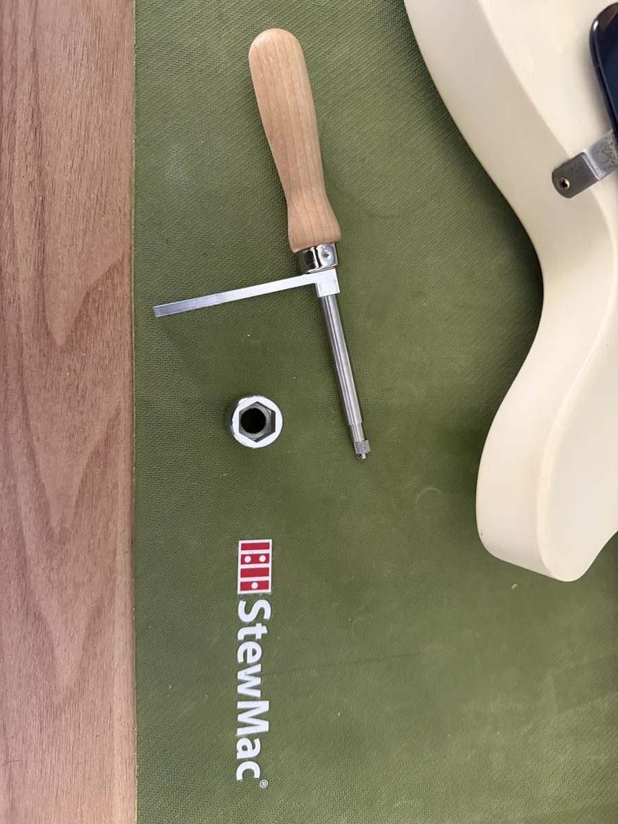 StewMac Jack-the-Gripper and its hex socket laid out on a bench mat next to the Les Paul