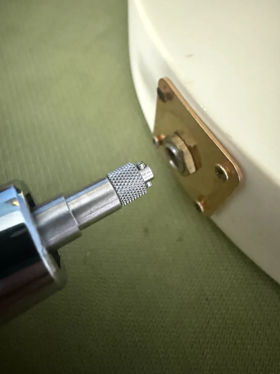 Knurled expanding tip of the Jack-the-Gripper lined up with the output jack on the Les Paul