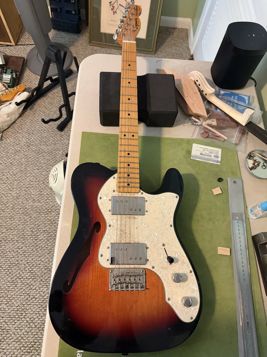 Well-used Squier semi-hollow Telecaster-style guitar before cleaning and pickguard replacement