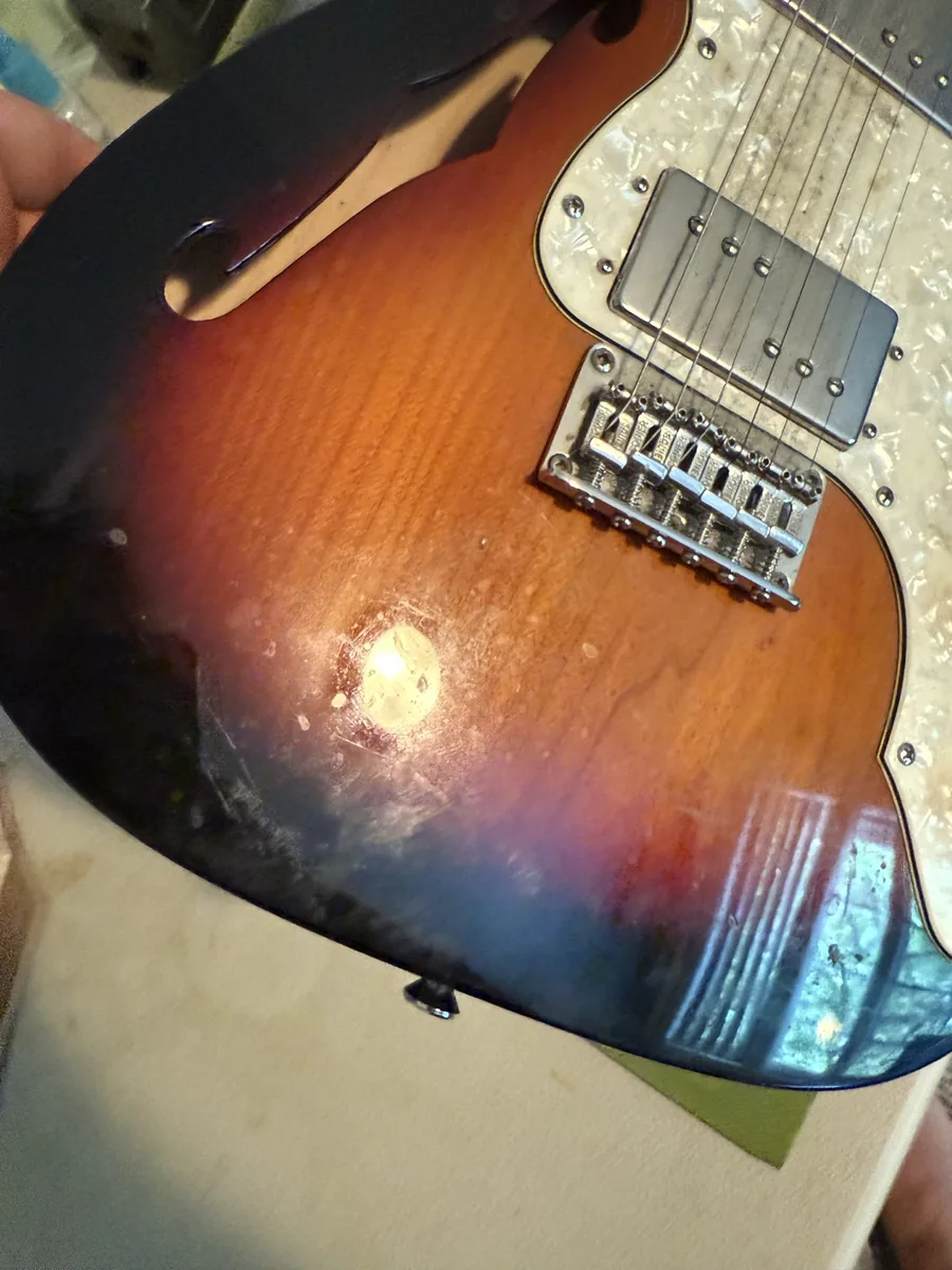 Close-up of dirt and grime on the body of an older Squier guitar