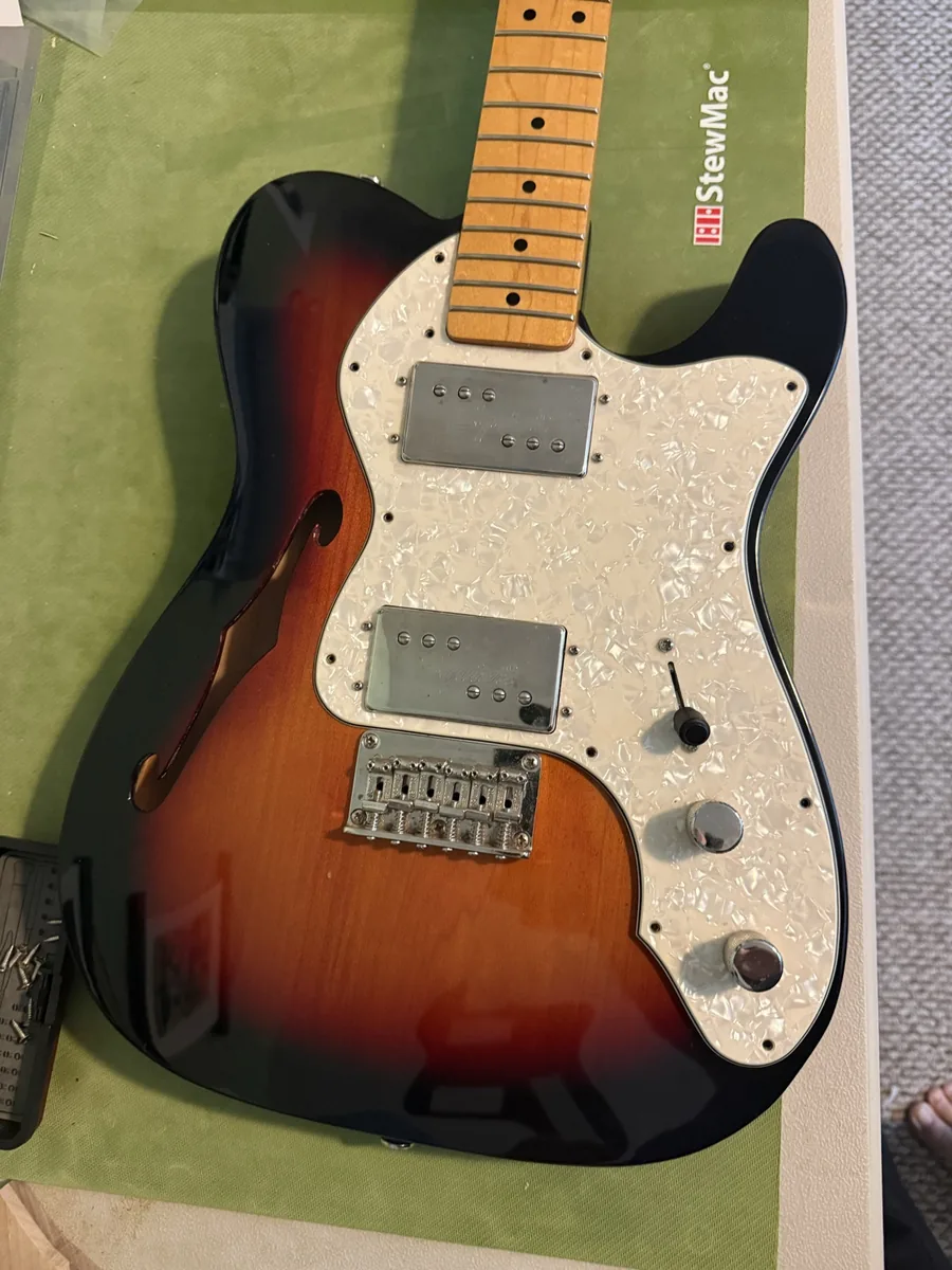 Original white pearloid pickguard on a Squier guitar