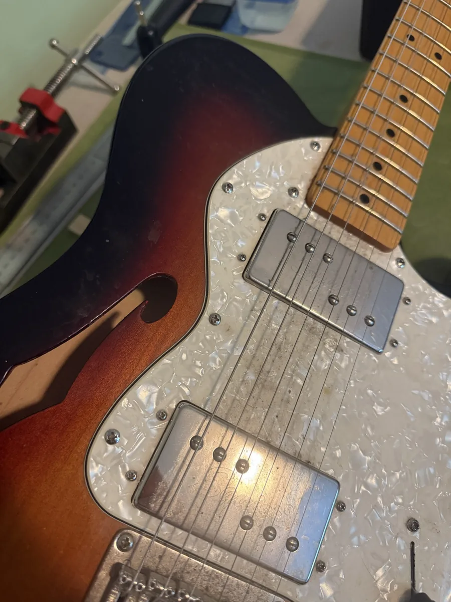 Dirty humbuckers and pearloid pickguard before restoration work