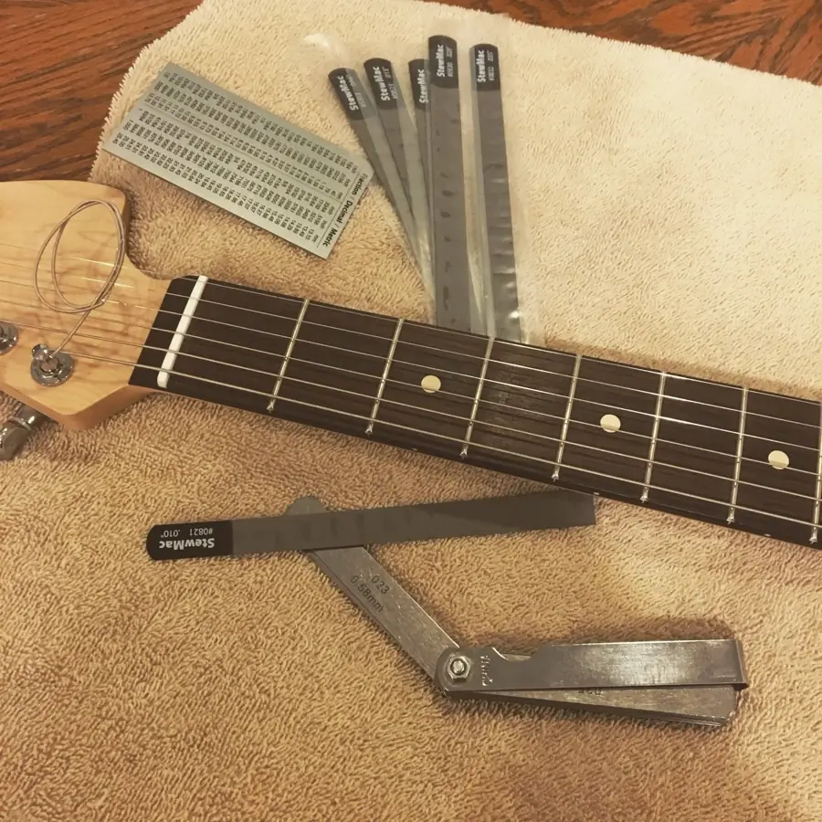 StewMac fret setup tools and action gauge on a guitar neck