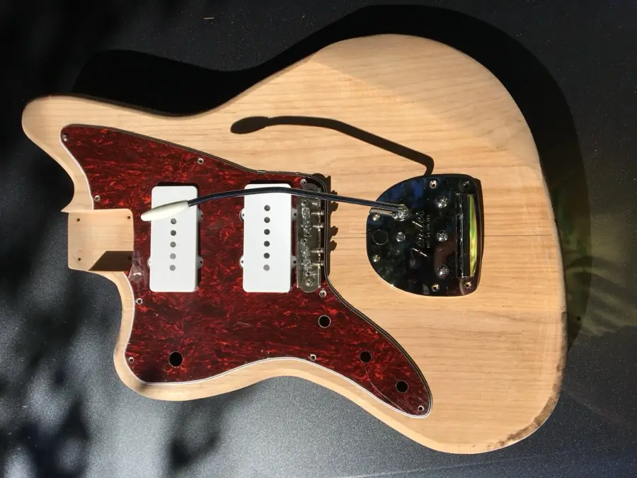 Wiring harness and pickups mounted to a tortoise pickguard on a raw body