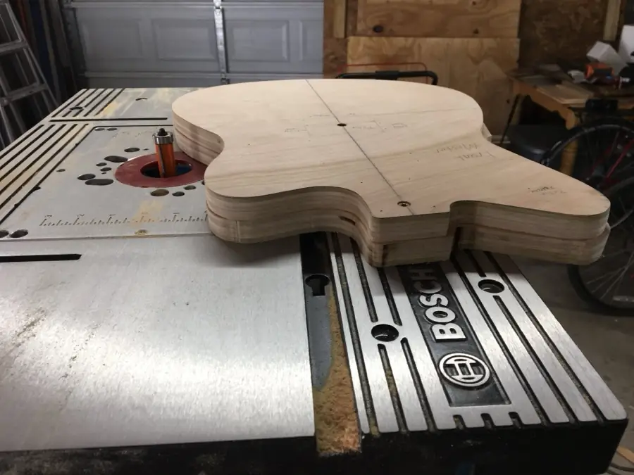 Guitar body blank being template-routed on the router table